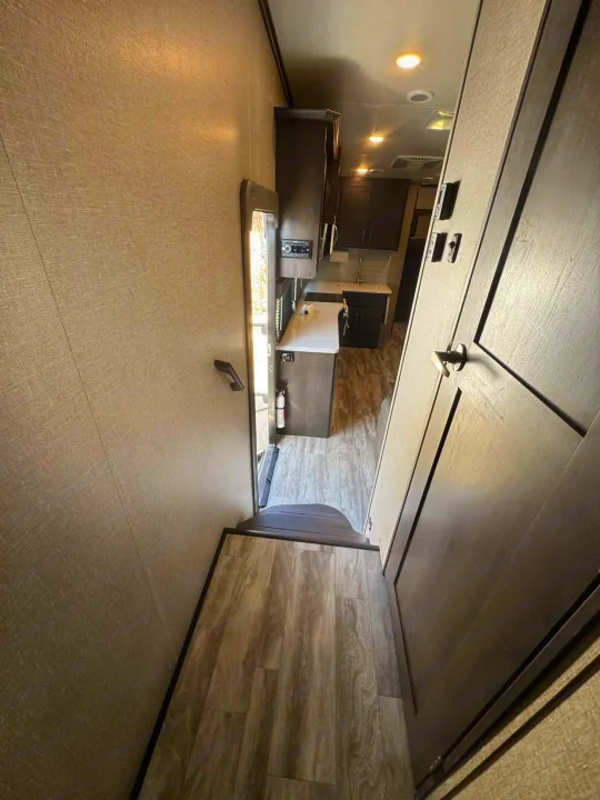 Inside this RV rental: a modern kitchen, textured walls, wood-look flooring, and hallway. Ready for your adventure.. Grand Design Reflection 2022