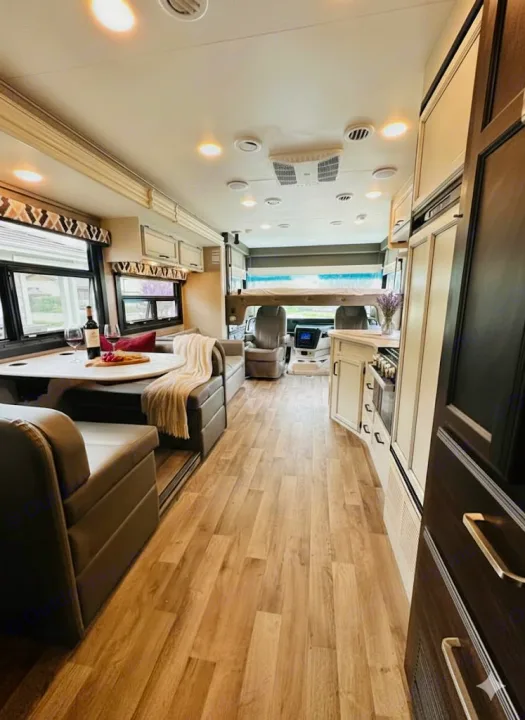 Spacious, modern RV rental interior features a living/dining area, full kitchen, and cab-over bed for comfortable travel.. Jayco Alante 2021