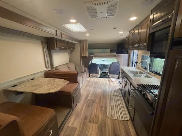 Step into this RV rental, showcasing a full kitchen, comfortable dinette, and a cozy living area.. Jayco Greyhawk 2019