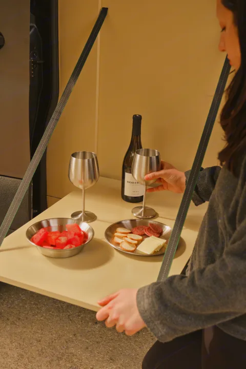 RV rental: A person enjoys wine, watermelon, cheese, & crackers on a suspended table, perfect for van life dining.. Mercedes Sprinter 2022