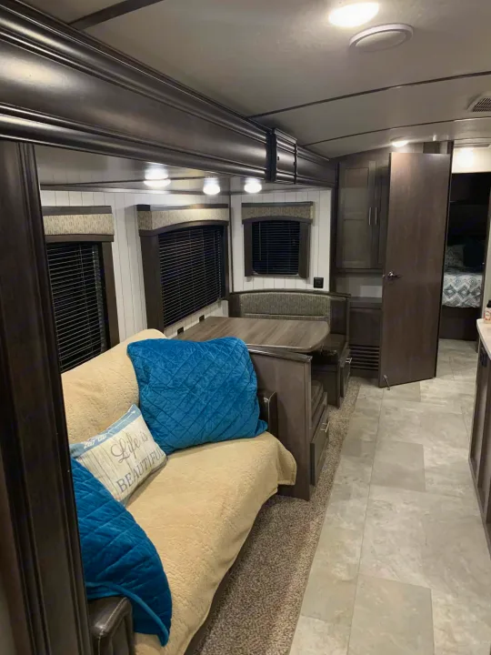 Cozy RV rental interior: living area with sofa, dinette, and bedroom access.. Crossroads RV Sunset Trail Super Lite 2018
