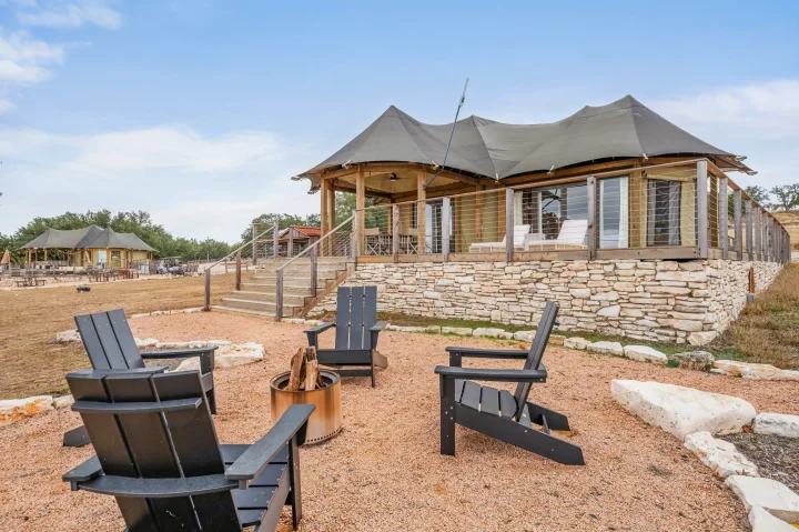 Relax by the fire pit at this glamping tent resort, an ideal getaway for your RV rental adventure. Enjoy the outdoor deck.