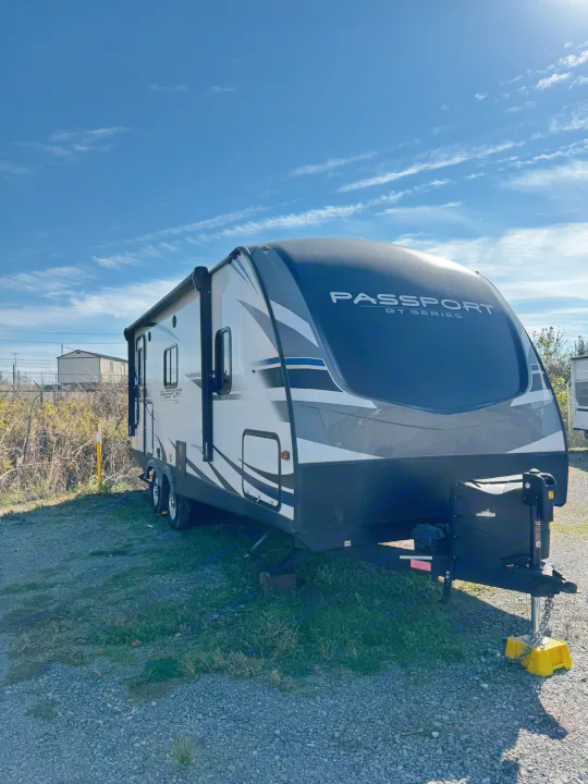 A 'Passport GT Series' travel trailer, perfect for an rv rental, is parked on a sunny day, ready for adventure.. Keystone RV Passport Grand Touring 2019