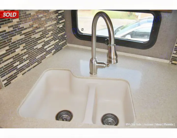 Modern RV rental kitchen with a large double sink, pull-down faucet, and stylish mosaic backsplash over spacious counters.. Holiday Rambler Endeavor 2018