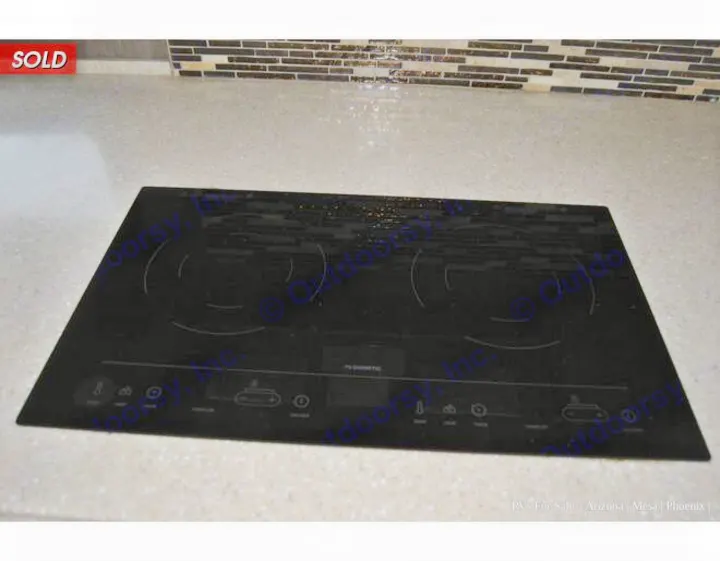 Sleek black Dometic induction cooktop built into a light countertop, ideal for your next rv rental kitchen.. Holiday Rambler Endeavor 2018