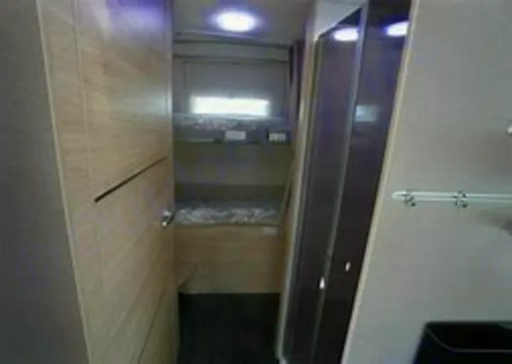 RV rental interior: Bunk beds, compact shower, and storage offer family comfort in this camper.. Chausson 720 VIP Titanium 2021
