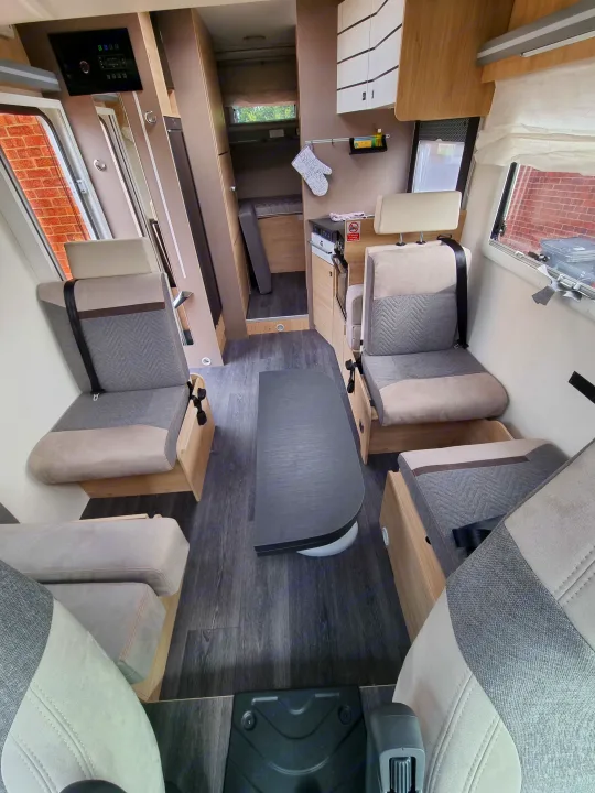RV rental interior: dining area with belted seats, kitchen, and compact rear bunk bed. A functional space for road trips.. Chausson 720 VIP Titanium 2021