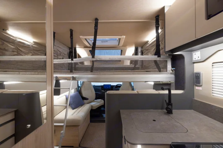 Explore this practical rv rental interior: overhead bunk, kitchen with sink, and cozy seating. Ready for your journey.. Auto-Trail F70 2025