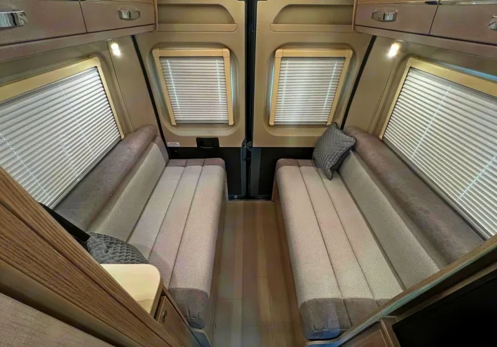 Inside a clean RV rental, offering flexible seating/sleeping via two cushioned benches with privacy blinds for your next adventure.. Elddis CV80 2024