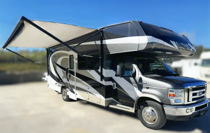 Ready for adventure! This sleek Class C rv rental features a dark, white, and gray design with an extended awning.. Coachmen Leprechaun 2020