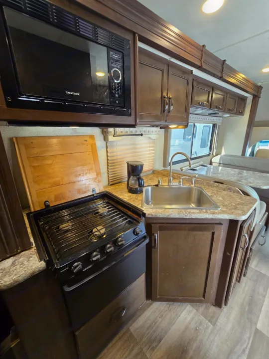 This RV rental offers a well-equipped kitchen with microwave, stovetop, sink, and coffee maker, perfect for your travels.. Thor Four Winds 2019