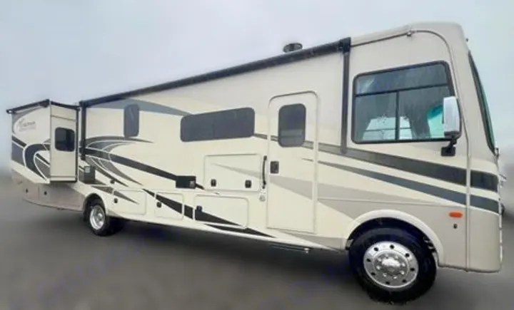 An off-white RV rental motorhome with a slide-out extended, featuring stylish black & grey decals. Perfect for your next trip!. Coachmen Encore 2021