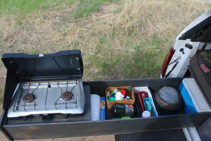 RV rental outdoor kitchen setup: a pull-out drawer from a vehicle with a camping stove, utensils, & supplies.. Ford Ford F150 2024