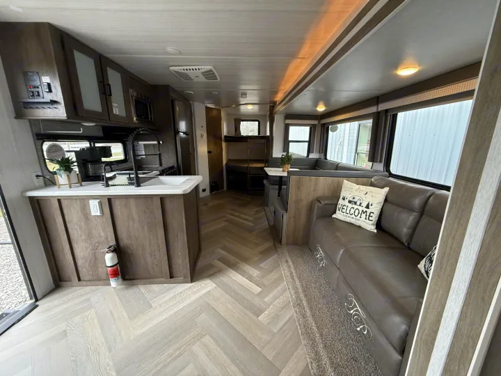 Spacious RV rental interior with a modern kitchen, comfortable living space, dinette, and bunk beds, ideal for travel.. Forest River Salem 2022