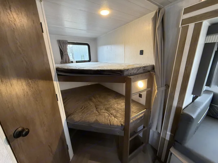 Comfortable RV rental bunk beds with a window, ceiling light, and individual bunk lighting for a great night's sleep.. Forest River Salem 2022