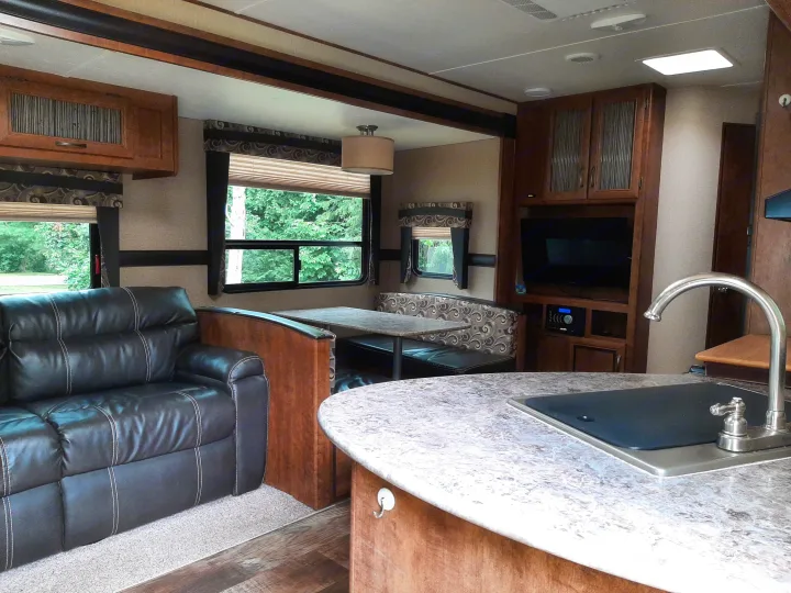 Inside this **rv rental**: a spacious living area with leather sofa, a comfy dinette, and a functional kitchen.. Crossroads RV Zinger 2017