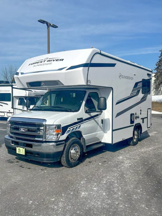 A pristine white Ford Class C RV rental, a Forest River Sunseeker motorhome, parked outdoors under a blue sky.. Forest River Sunseeker 2027