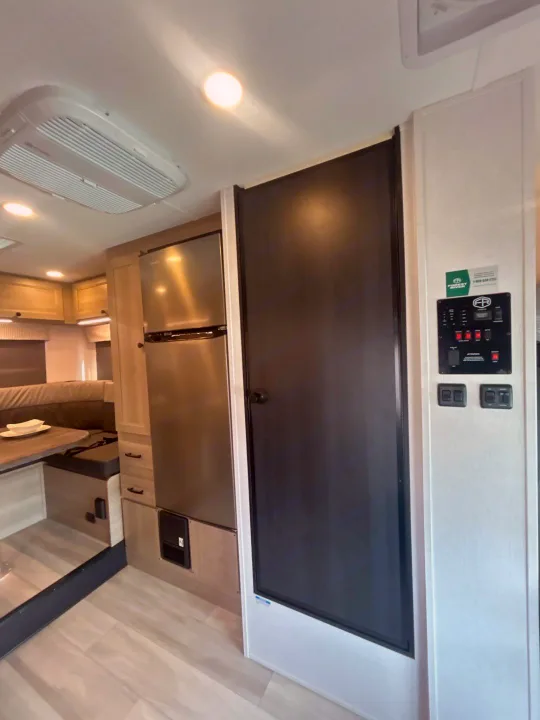 Inside this rv rental, find a modern kitchen with a fridge, comfortable dinette, ceiling AC, and a control panel.. Forest River Sunseeker 2027