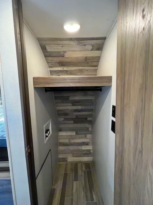 This RV rental offers a compact closet, ideal for storage, with a laundry hookup and modern wood-look accents.. Crossroads RV Zinger 2021