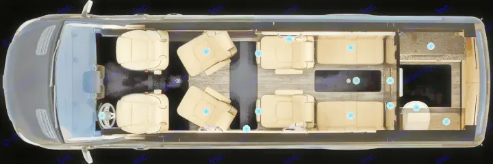 Overhead view of a luxury RV rental's interior. Shows beige driver/swivel seats, bench seating, a central table, and a rear kitchen area.. Ultimate Toys Ultimate Coach 2024