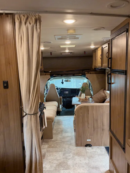 Spacious RV rental interior showcasing a cozy living area, kitchen, and cockpit. Ideal for your next motorhome adventure.. Coachmen Freelander 26 RS 2017