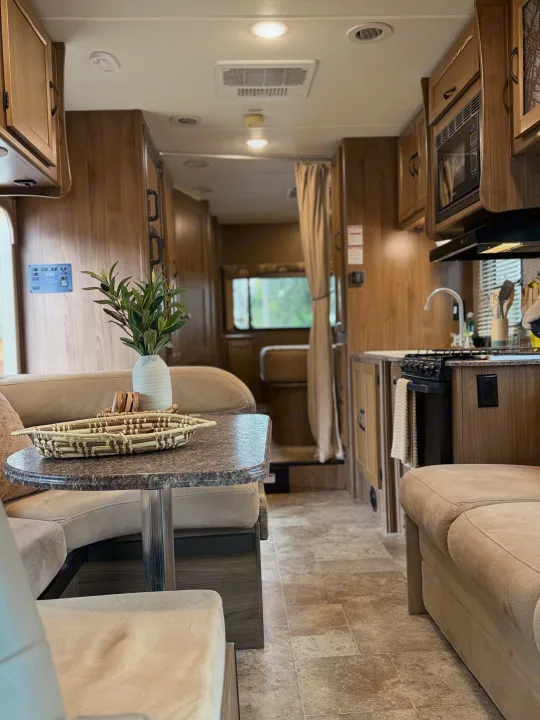 Spacious rv rental interior featuring a dinette, kitchen, and warm wood accents.. Coachmen Freelander 26 RS 2017