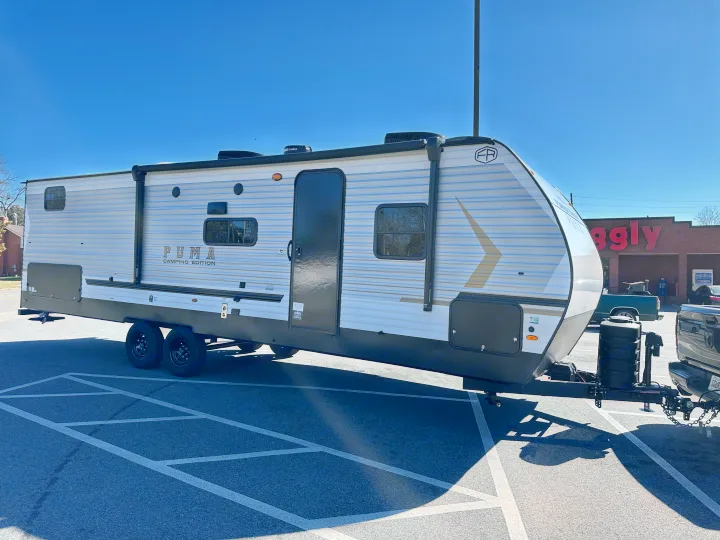 A Puma travel trailer RV rental is hitched in a sunny parking lot, ready for your next camping adventure or road trip.. Forest River Palomino Puma Camping Edition 2025