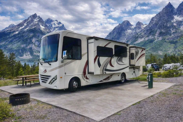 Enjoy a scenic RV rental experience! This motorhome is set up at a mountain campground with full hookups, slide-outs, and a fire pit.. Thor Hurricane 2017