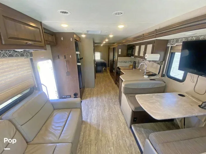 This spacious RV rental features a living area with a sofa, kitchen, dinette, and bedroom, perfect for travel.. Thor Hurricane 2017