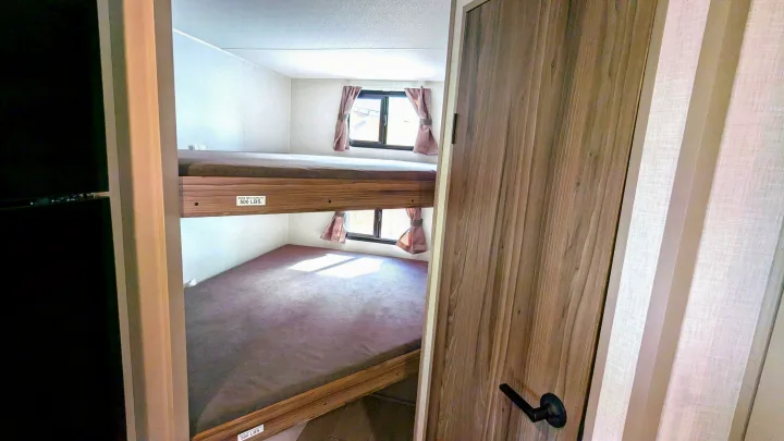 Compact RV rental bunk beds, each with 500 lbs capacity, and a window in the sleeping area.. KZ Connect SE 2025