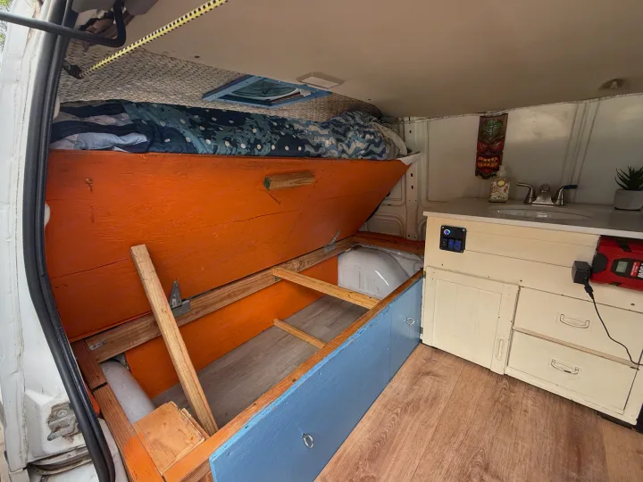 Explore this RV rental's cozy custom interior, featuring a convertible bed, storage, sink, and power for off-grid adventures.. Chevrolet Other 2005