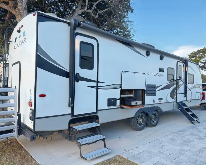 Spacious Cougar by Keystone RV rental features an outdoor kitchen, steps, and awning, ready for adventure.. Keystone Cougar Half-Ton 2020