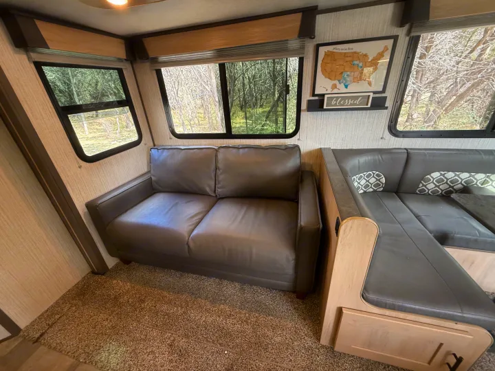 Spacious RV rental interior with a comfy sofa, dinette, and scenic window views, ideal for your next camper adventure.. Cruiser RV Radiance Ultra Lite 2020