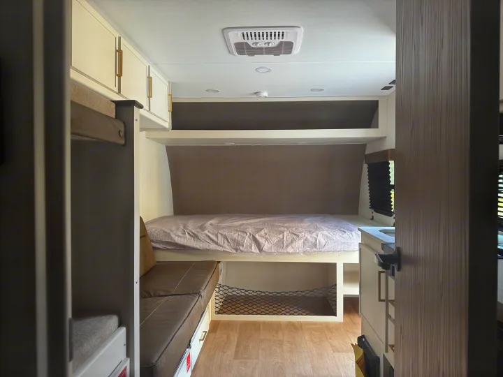 Explore this modern rv rental interior, featuring bunk beds, a main sleeping area, and smart storage for comfortable travel.. Transcend One 151BH 2026