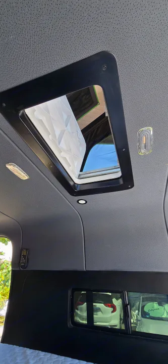 Inside your RV rental: a bright camper van ceiling with an open roof vent for fresh air and natural light.. Mercedes Sprinter 2023