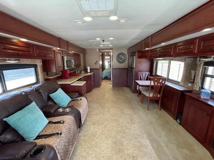 Comfortable RV rental interior featuring a full kitchen, dining nook, and living area, with a bedroom visible beyond.. Berkshire Berkshire Motorhome 2013