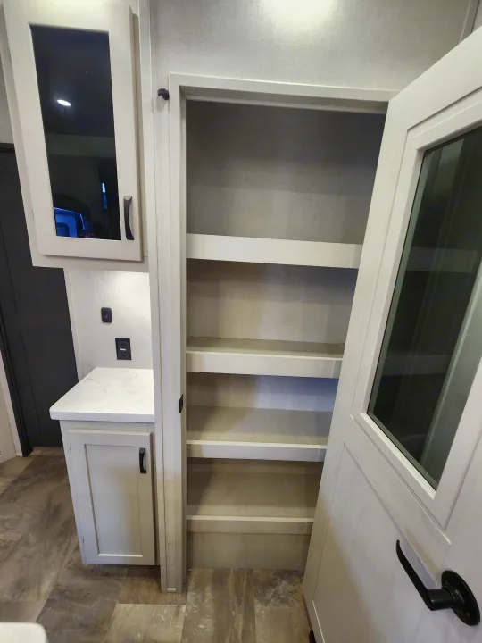 RV rental: Modern interior featuring an open pantry with multiple shelves, adjacent counter, and overhead cabinet for ample storage.. phoenix 334FL 2026