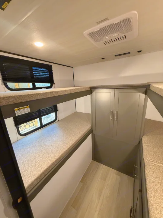 RV rental bunk beds, storage cabinet, and AC unit provide comfortable lodging for guests.. Keystone Bullet 2026