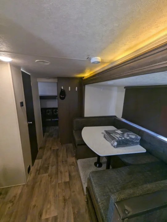 rv rental interior: a cozy dinette with U-shaped bench seating, a table, and wood-look floor, illuminated by ceiling and accent lights.. Forest River Salem Cruise Lite 2018