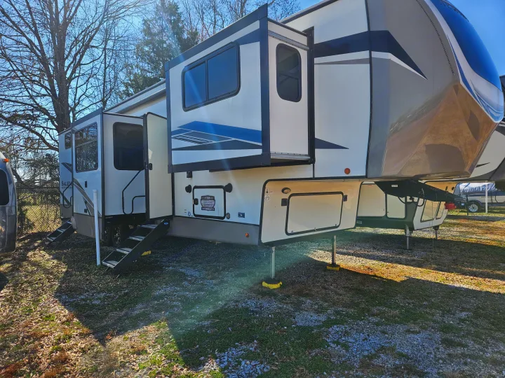 Spacious fifth-wheel RV rental parked outdoors, ready for your next adventure. Features extended slide-outs, steps, and storage.. Forest River Hemisphere 2021