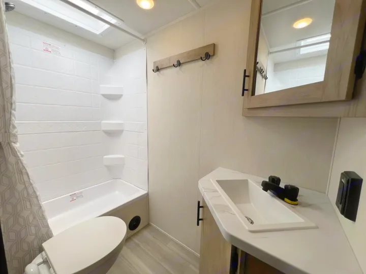 Modern RV rental bathroom with compact shower, toilet, and sink vanity.. Forest River Campsite Reserve 2026