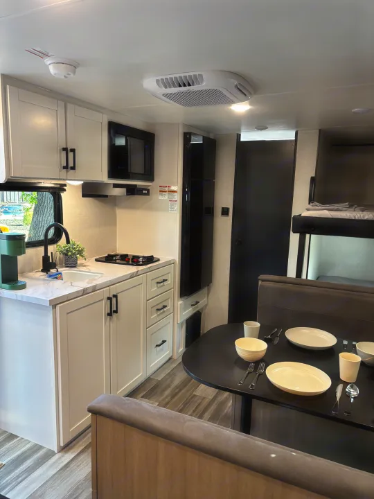 Modern RV rental interior featuring a compact kitchen, dining area, bunk beds, and essential amenities for your trip.. Jayco Jay Flight SLX 2026