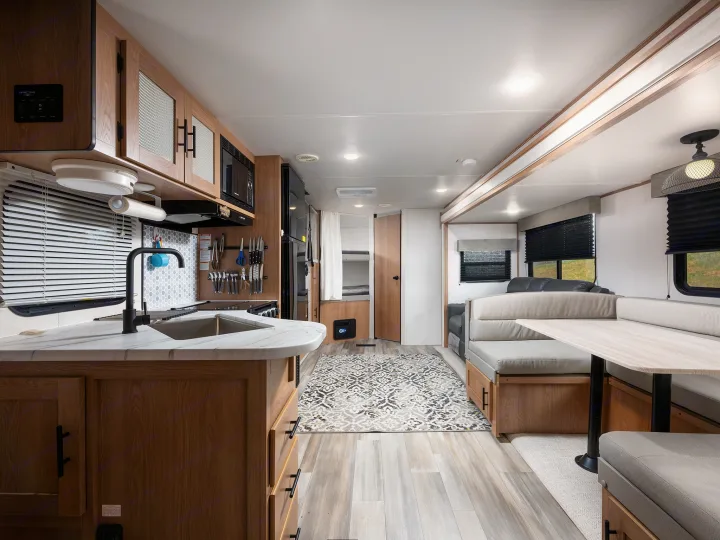Spacious RV rental interior featuring a full kitchen, dining area, and comfortable sleeping bunks for your next adventure.. Prime Time Avenger 2024