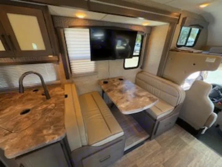 RV rental: Spacious interior featuring a dinette with TV, kitchen counter, and sink.. Thor Chateau 2023