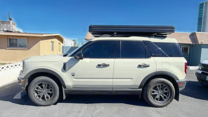 Light-colored Ford Bronco Sport with a black rooftop tent, an ideal rv rental for outdoor adventures and camping.. Ford Bronco Sport 2024