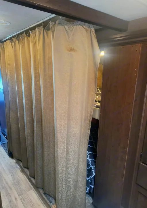 RV rental bunk privacy: Light curtain on track, dark wood cabinet, patterned bedding visible in this interior view.. Thor Motor Coach Freedom Elite 2019