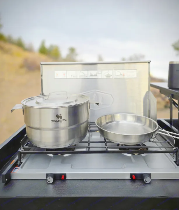 RV rental outdoor cooking: Stanley pot and pan on a portable two-burner stove, set up for meals amidst nature.. Dirtbox Overland Canopy Camper 2023