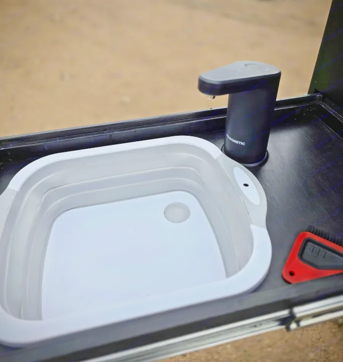 RV rental ready: Dometic portable faucet & collapsible sink for convenient outdoor dishwashing, perfect for camping hygiene.. Dirtbox Overland Canopy Camper 2023