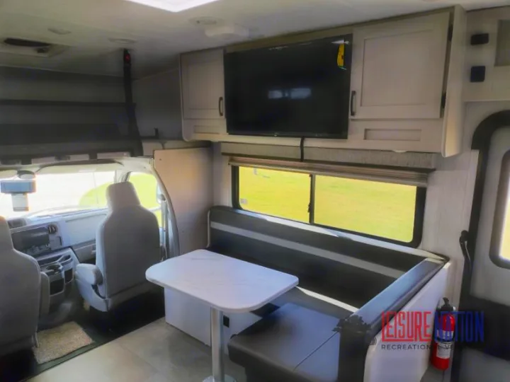 Spacious RV rental interior featuring a dinette, overhead bunk, cockpit, and entertainment for comfortable travel.. Coachmen Freelander 2023