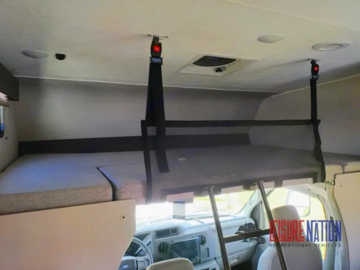 Spacious cab-over bunk in an RV rental, featuring a comfortable sleeping area with safety net and access ladder. Perfect for families.. Coachmen Freelander 2023